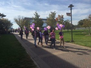 Students walk through campus to commemorate both Breast Cancer Awareness Month and Domestic Violence Awareness Month. Photo by Maliik Obee