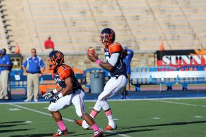 Moses Skillon (12) drops back to pass as Orlando Johnson (1) blocks. Photo by Benjamin McKnight III