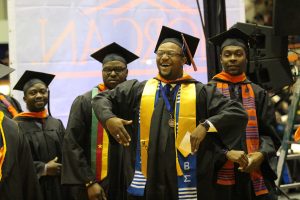 Jamal Butler celebrates on his way to the stage to be recognized as a Winter 2015 graduate. Photo by Benjamin McKnight III