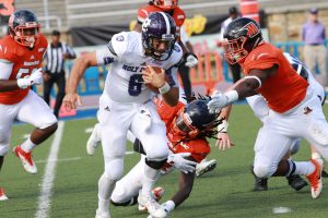 Holy Cross quarterback Peter Pujals scrambles for extra yardage. Photo by Terry Wright.