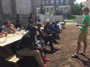 Volunteers from Morgan State University and Johns Hopkins University take a lunch break and learn about Habitat for Humanity. Photo by Jazmine Hawes.